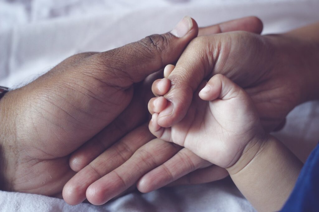 persons hand with white nail polish